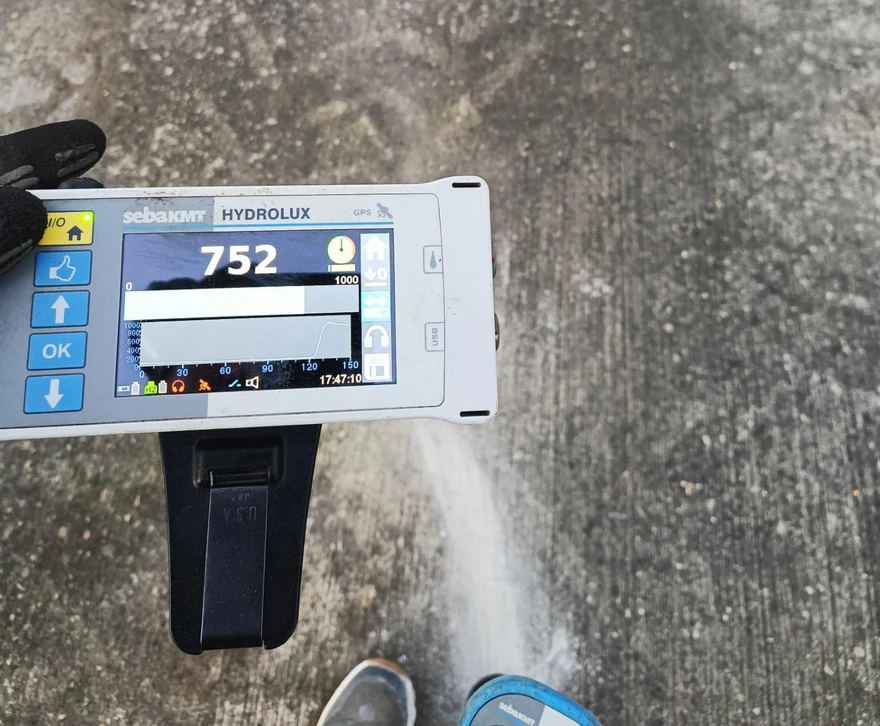 Mécanicien automobile portant des gants de protection orange tenant un stéthoscope de diagnostic moteur dans un garage professionnel